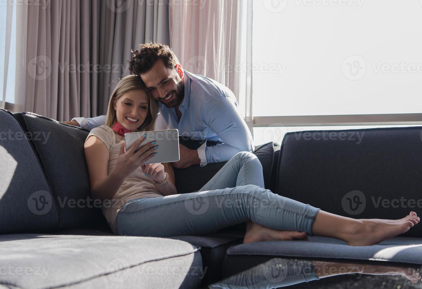 couple relaxing at  home using tablet computer photo