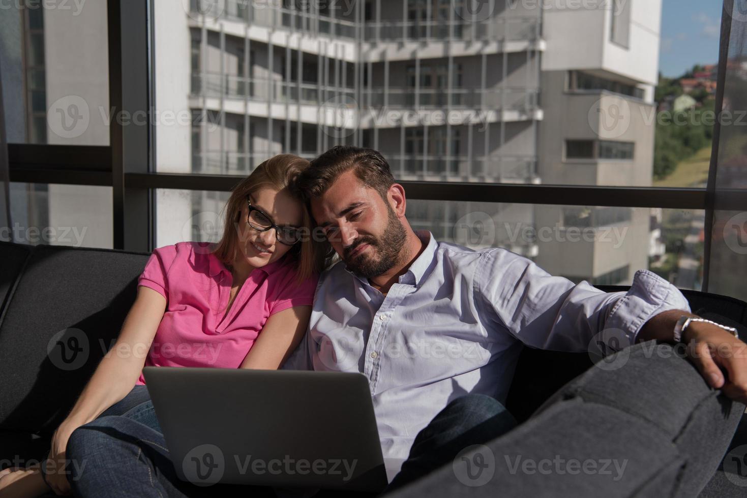 couple relaxing at  home using laptop computers photo