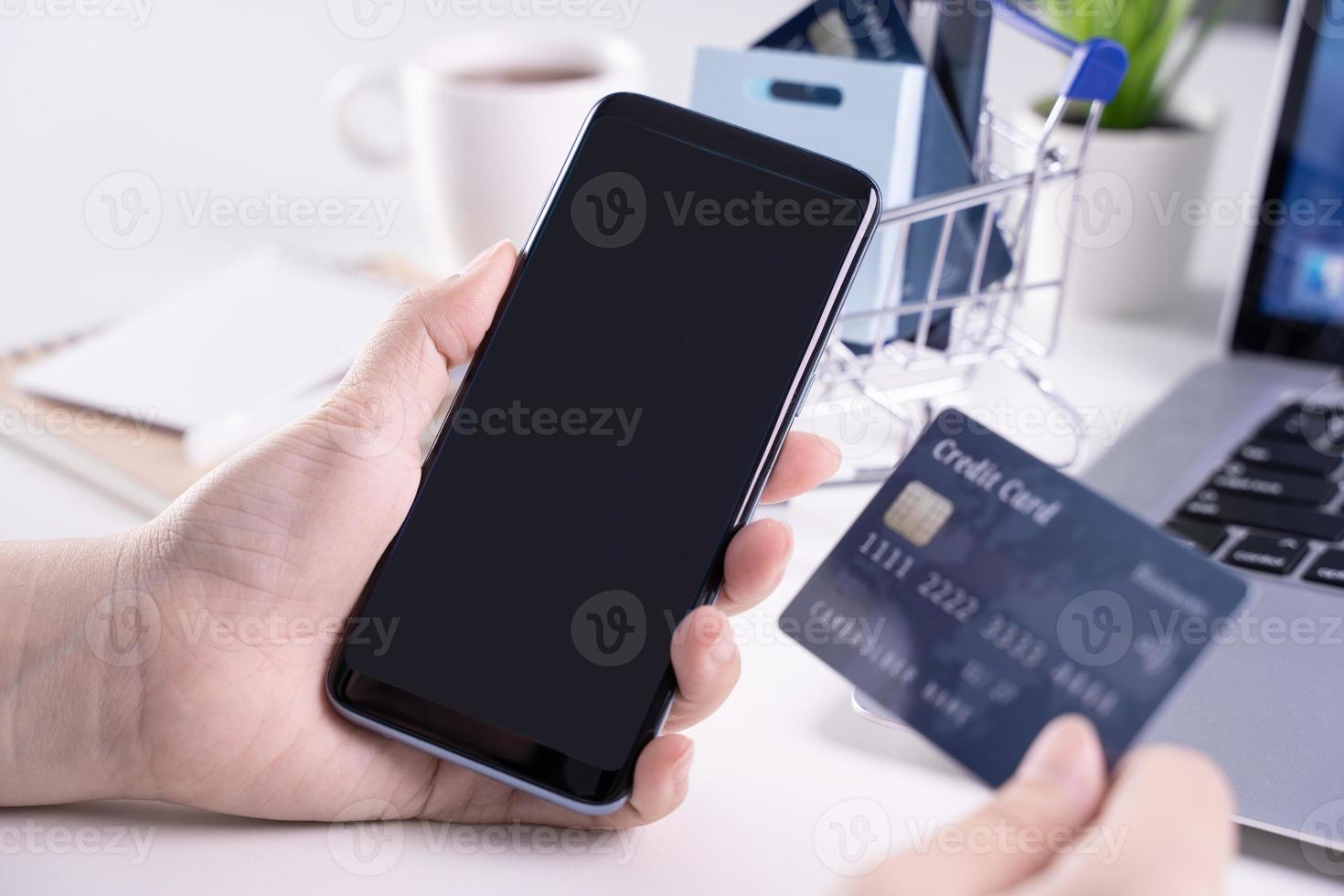 Office online paying, stay home shopping, electronic payment with credit card concept, laptop on white table background with shop cart, close up. photo