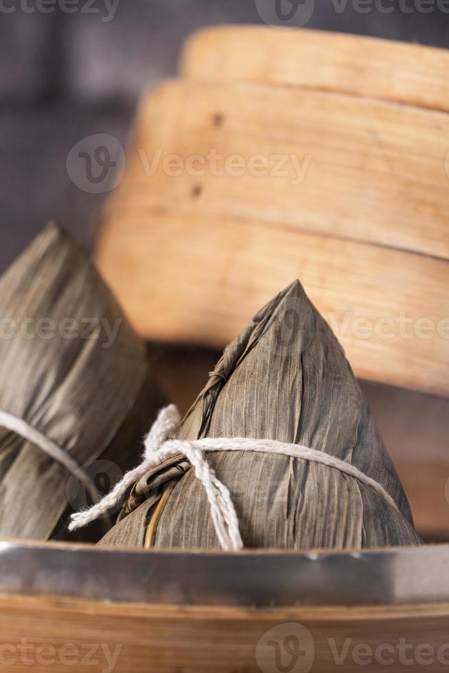 dumpling de arroz, zongzi - dumpling de arroz chino zongzi sobre una mesa de pizarra de fondo de ladrillo negro, concepto de comida tradicional del festival del barco del dragón, de cerca. foto