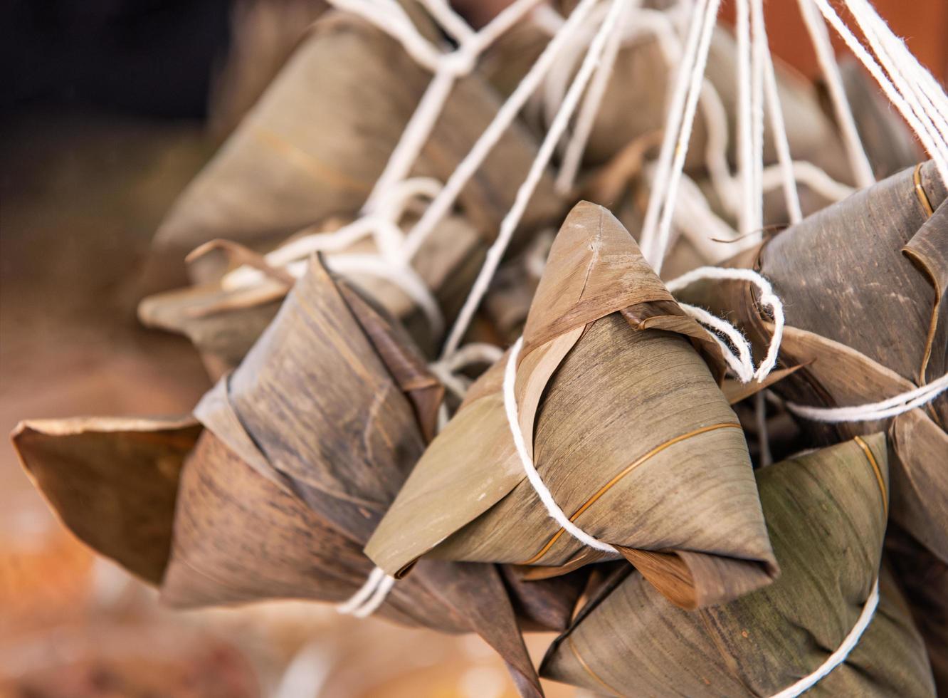 hacer zongzi - ingrediente de arroz chino dumpling zongzi haciendo en la mesa en casa para la celebración del festival del bote del dragón, primer plano, estilo de vida. foto