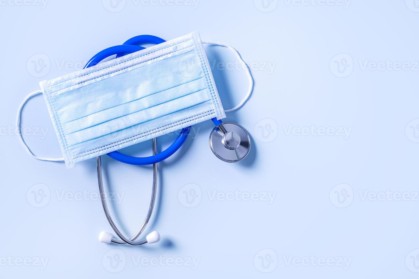 Blue mask - medical equipment with stethoscope, concept of world disease pandemic infection and prevention, top view, flat lay, overhead design photo