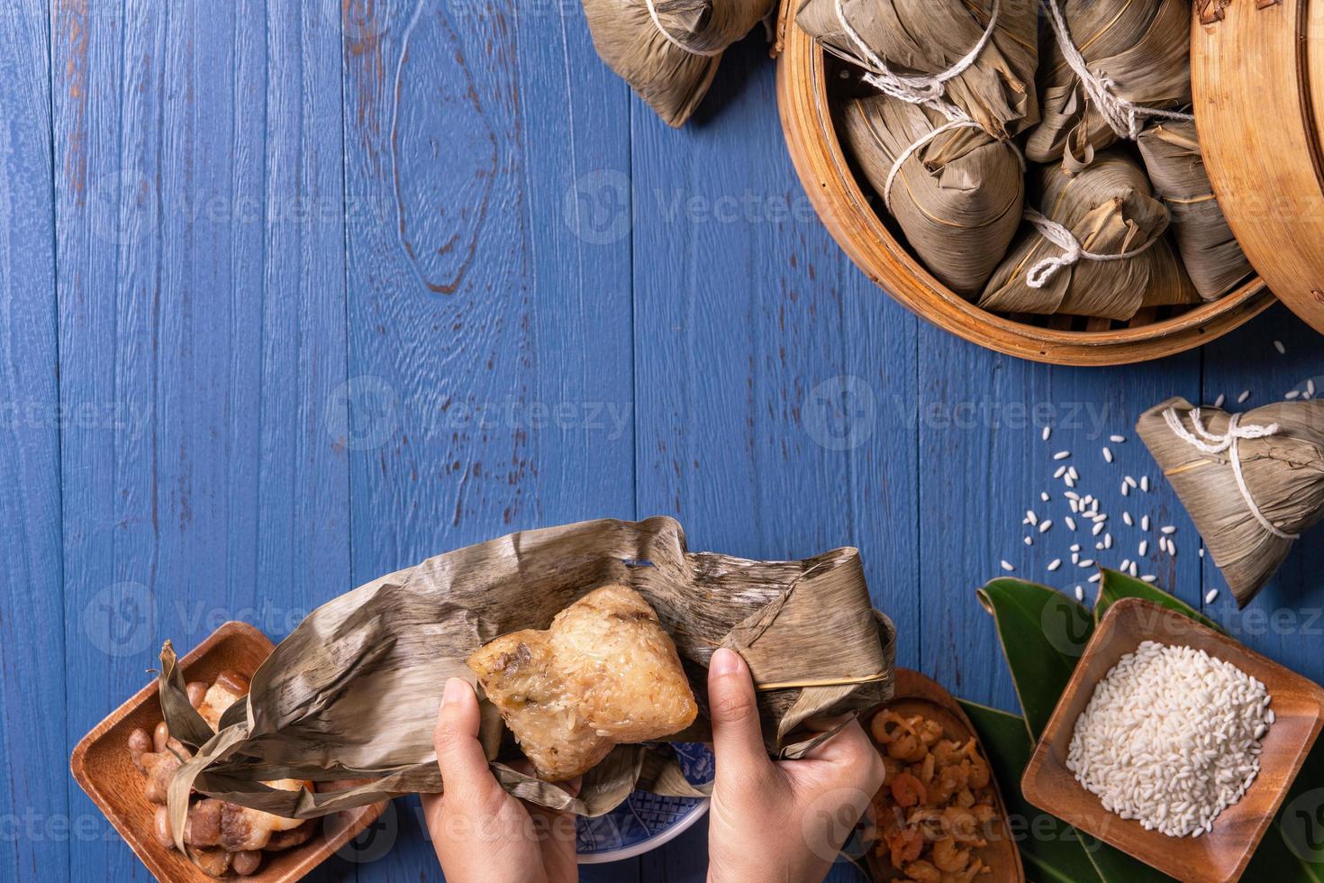 zongzi - bola de arroz con concepto del festival del bote del dragón, comida tradicional china sobre fondo de madera azul para el festival duanwu, vista superior, concepto de diseño plano. foto