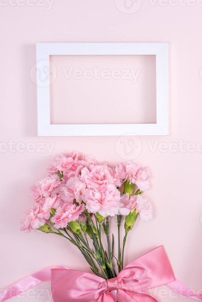 Mother's Day, Valentine's Day background design concept, beautiful pink carnation flower bouquet on pastel pink table, top view, flat lay, copy space. photo