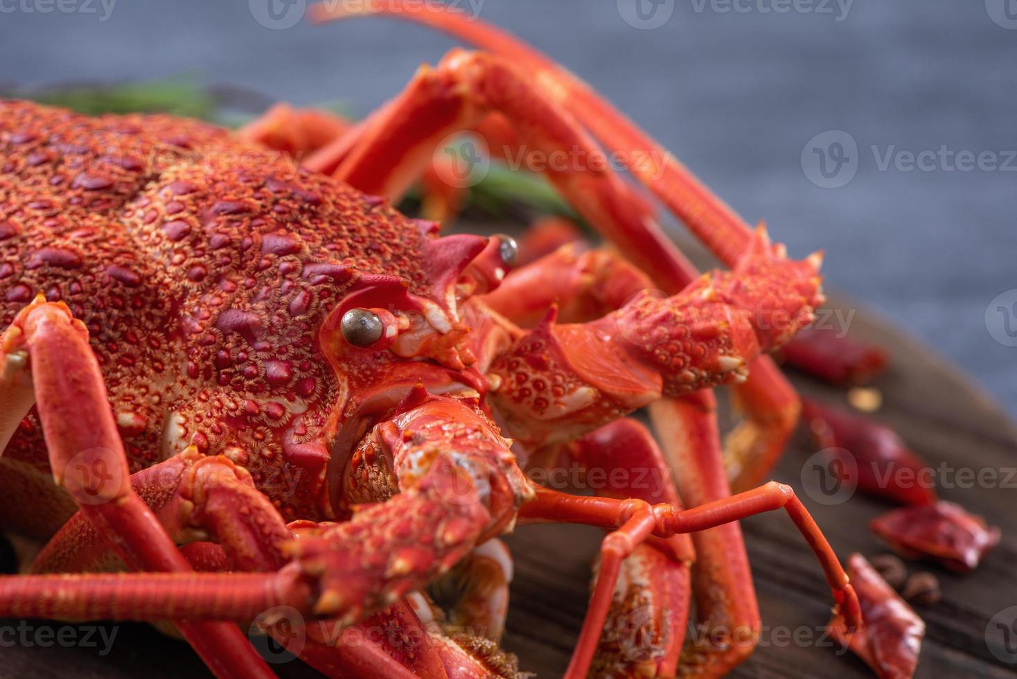 Cooked boiled lobster, delicious dinner seafood meal set with knife and fork on black stone slate background, restaurant menu design, close up, overhead photo