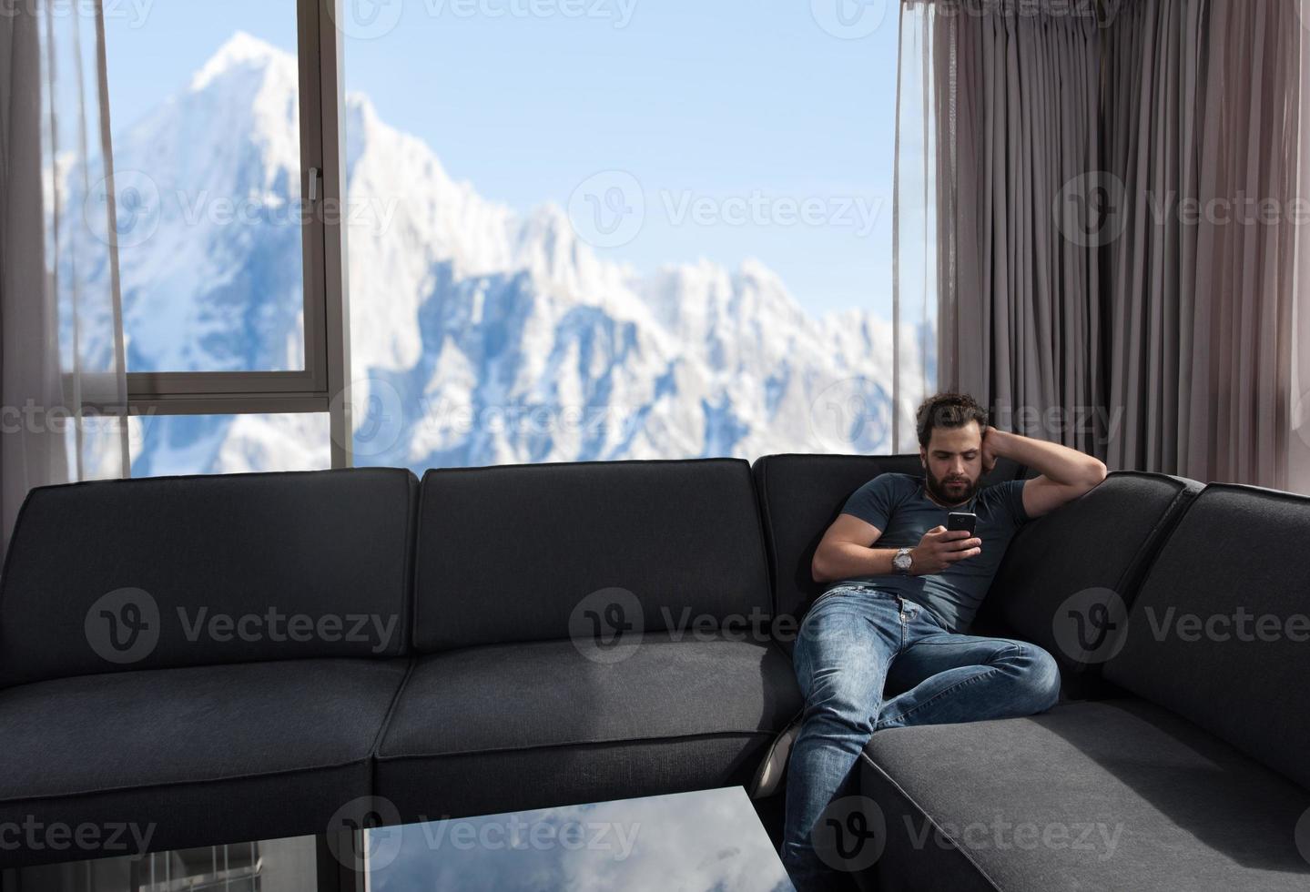 joven casual usando un teléfono móvil en casa foto