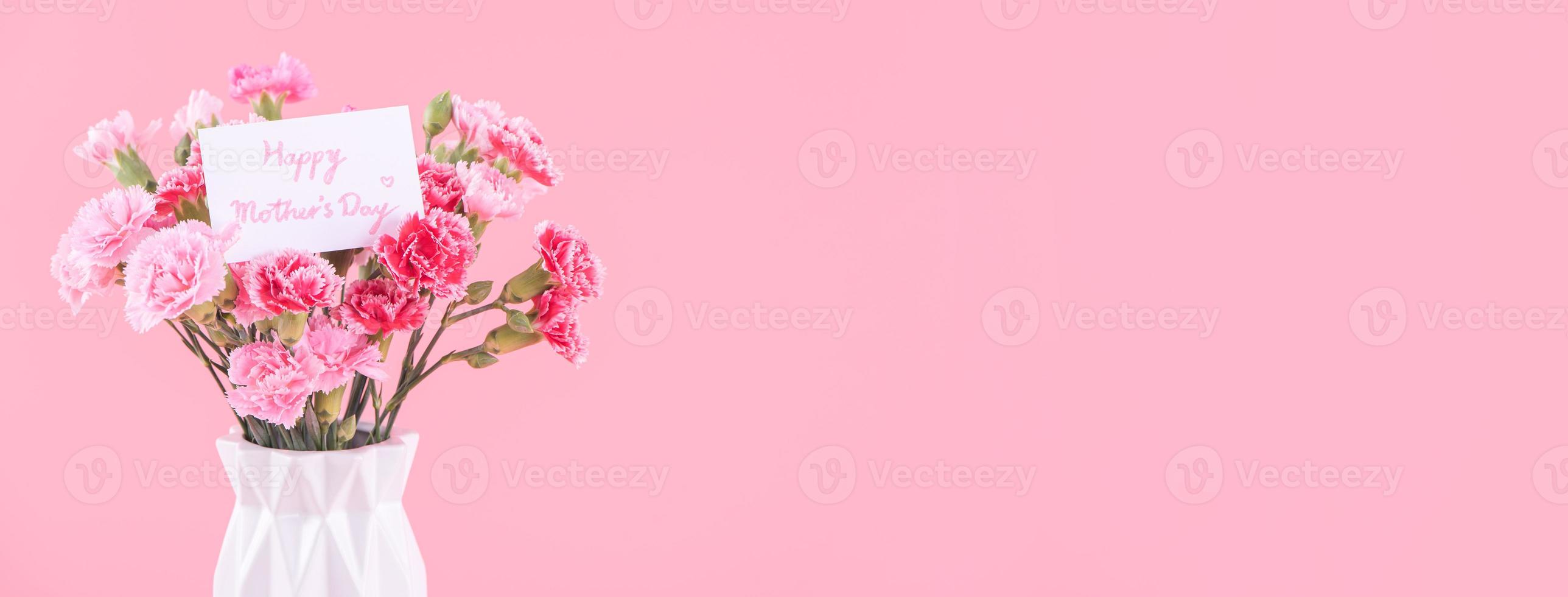 Mother's Day, Valentine's Day holiday gift design concept, pink carnation flower bouquet with wrapped box isolated on light pink background, copy space. photo