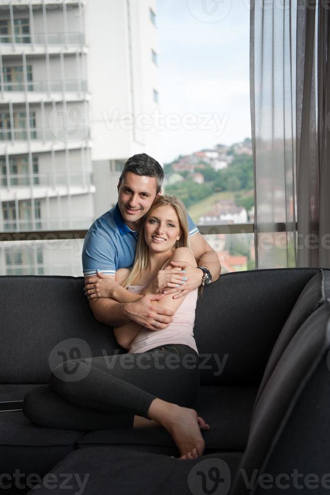 joven pareja guapa abrazándose en el sofá foto