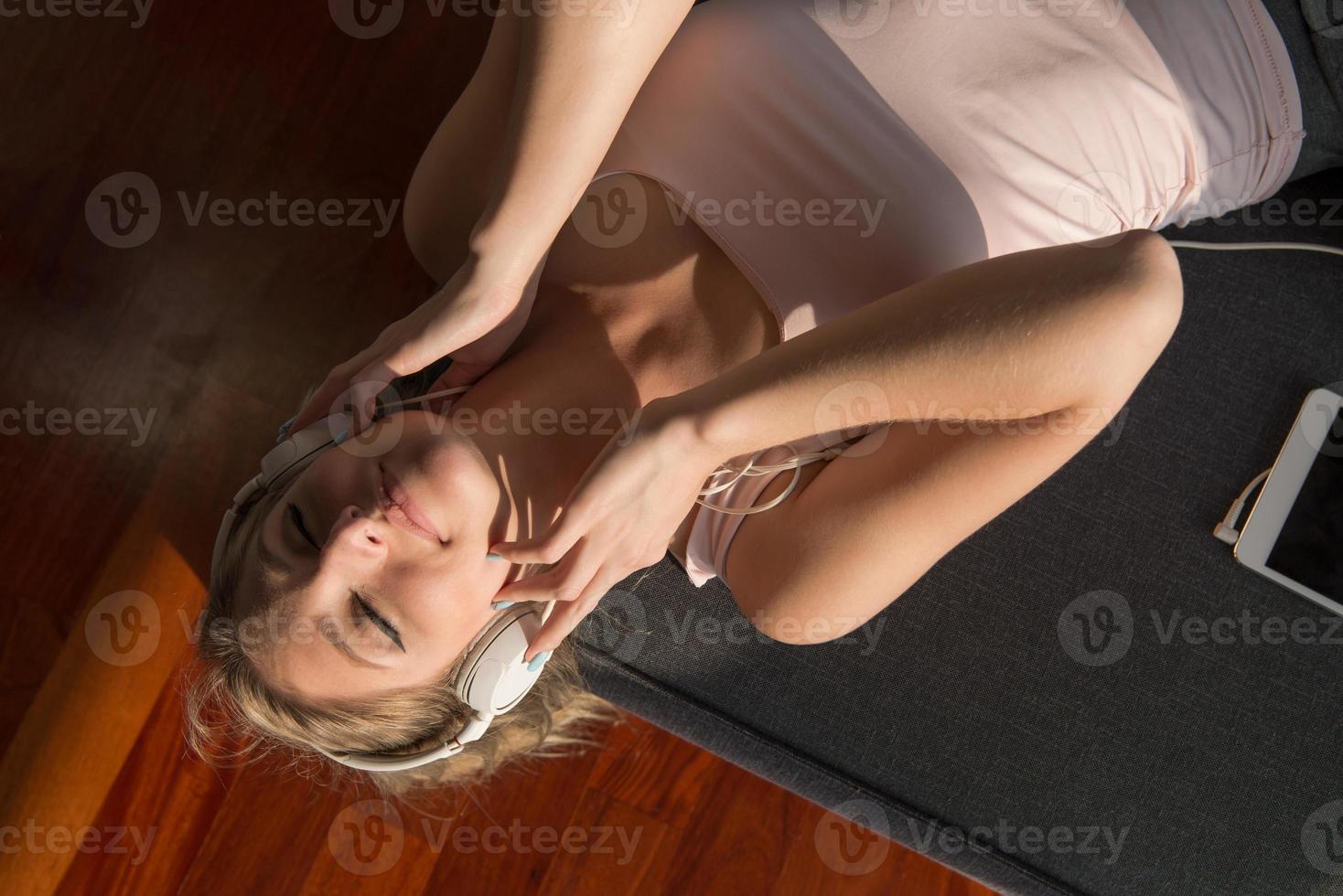 Lovely Blond Woman Listening To Music while resting on couch photo