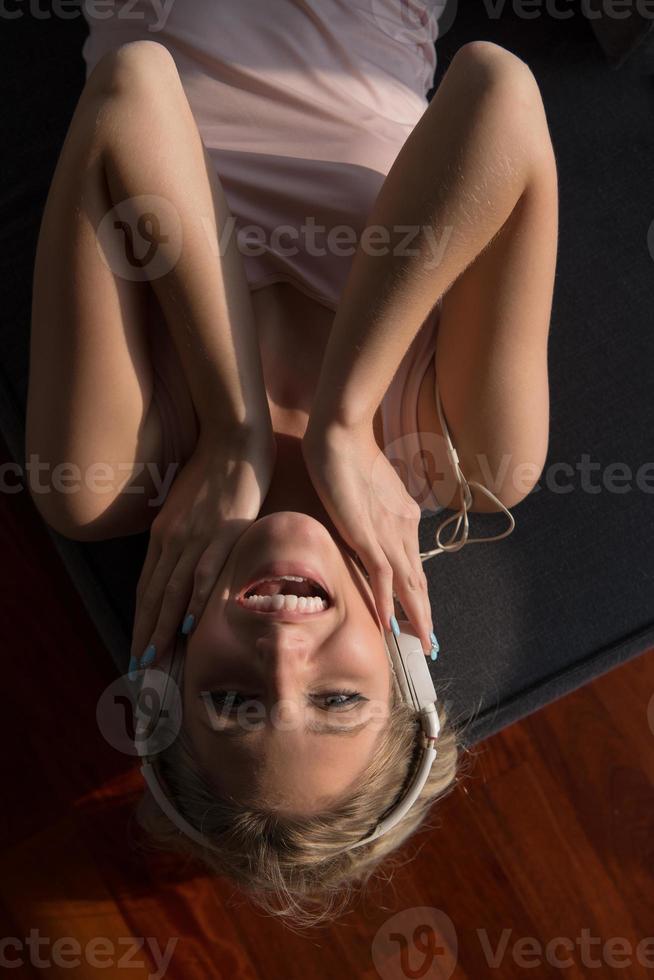 Lovely Blond Woman Listening To Music while resting on couch photo