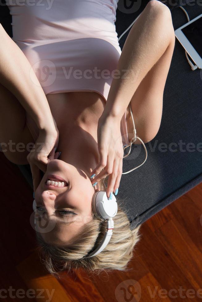 encantadora mujer rubia escuchando música mientras descansa en el sofá foto