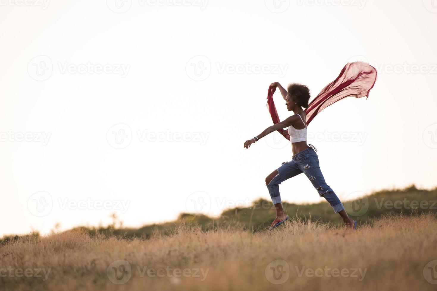black girl dances outdoors in a meadow photo