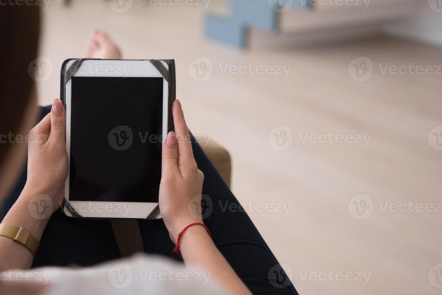 woman sitting on sofa with tablet computer photo