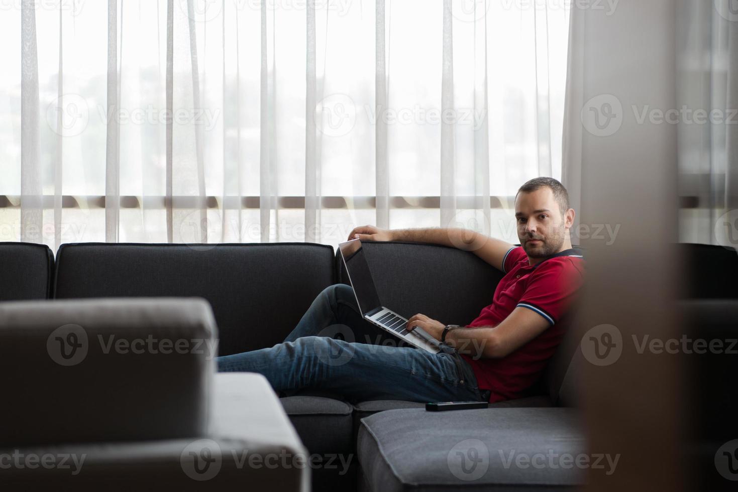 Man using laptop in living room photo