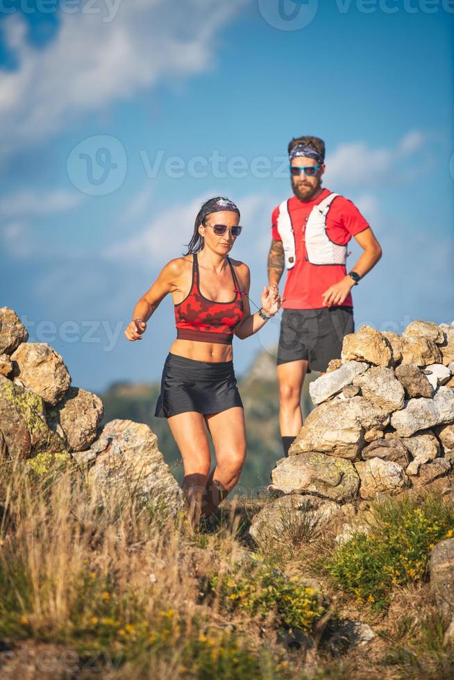 un entrenador personal lleva a su cliente a correr por las colinas foto