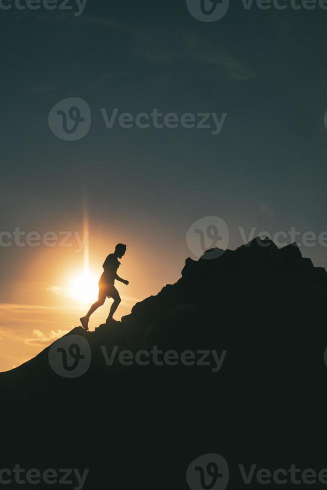 A man runs among the rocks in a colorful mountain sunset photo