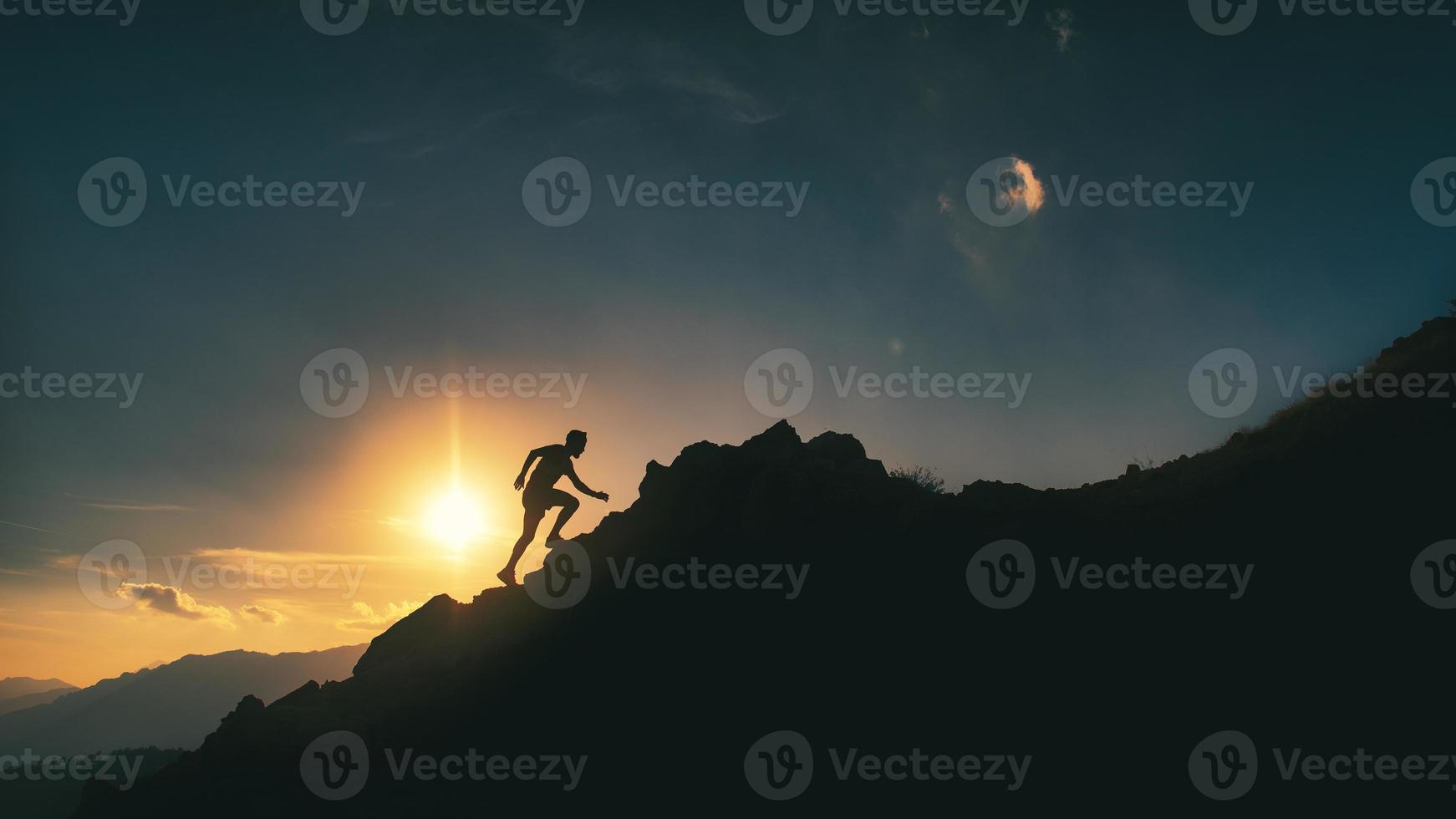 Man climbs a rocky mountain ridge in a picturesque sunset photo