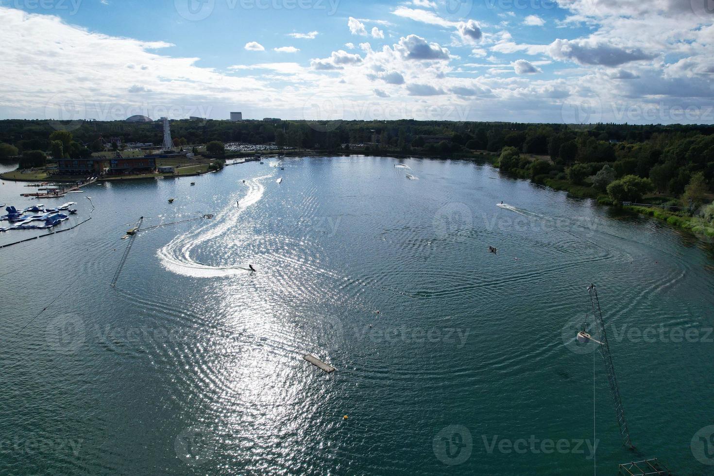 Beautiful Aerial Drone's Camera  Footage of Willen Lake and Park which is located at Milton Keynes, England. People are Enjoying at Lake on a Hot Sunny Day of Summer photo