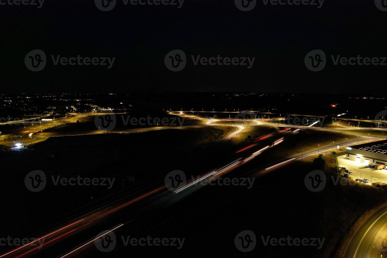 Night Aerial View of British Motorways with illuminated Roads and Traffic. Highways footage taken with drone's camera over Milton Keynes and motorways of England at Dark Night photo