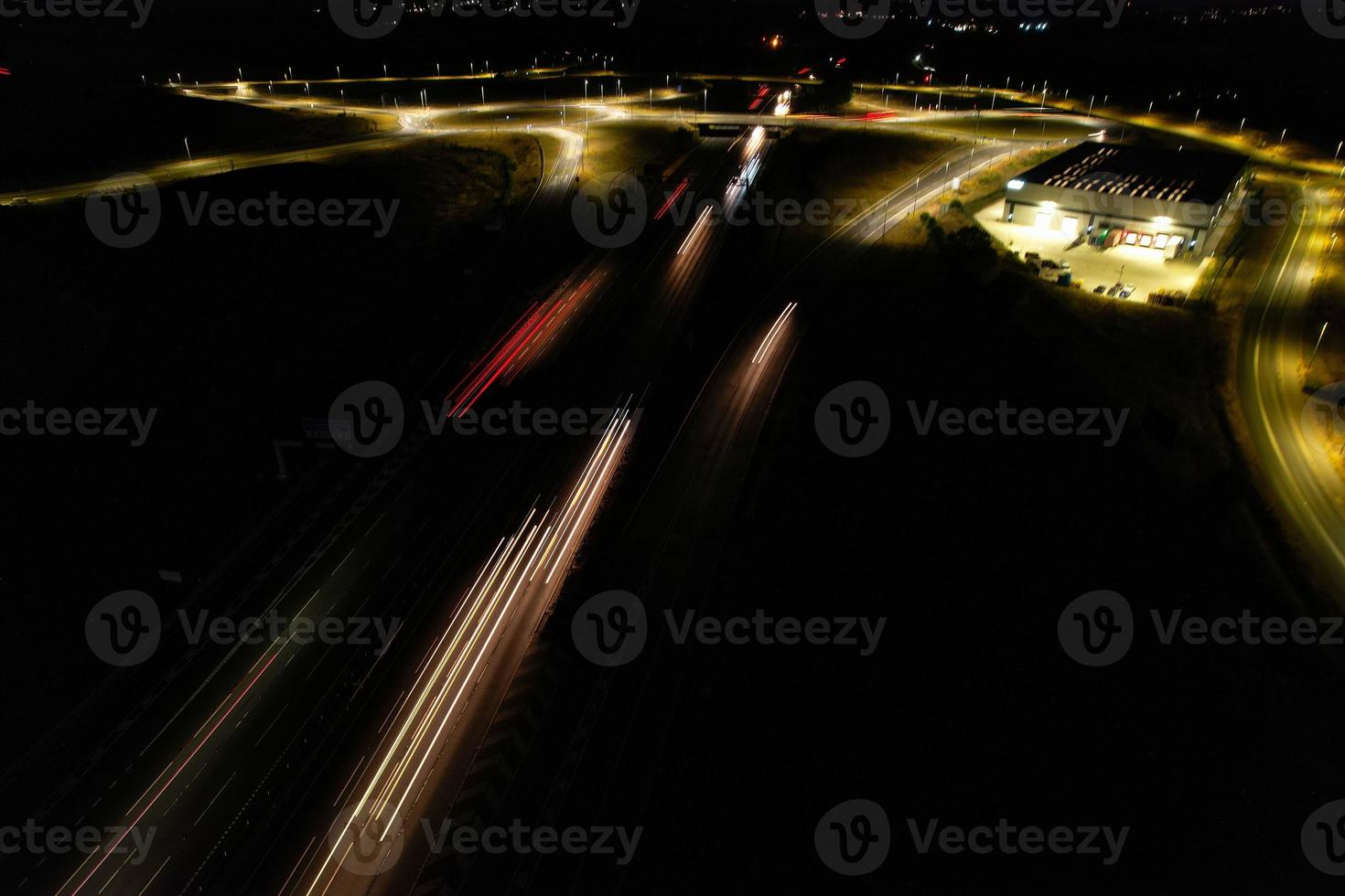 Night Aerial View of British Motorways with illuminated Roads and Traffic. Highways footage taken with drone's camera over Milton Keynes and motorways of England at Dark Night photo