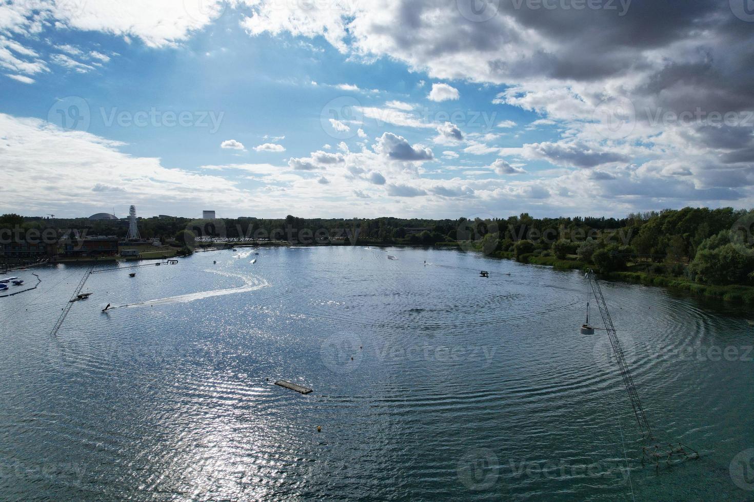 Beautiful Aerial Drone's Camera  Footage of Willen Lake and Park which is located at Milton Keynes, England. People are Enjoying at Lake on a Hot Sunny Day of Summer photo