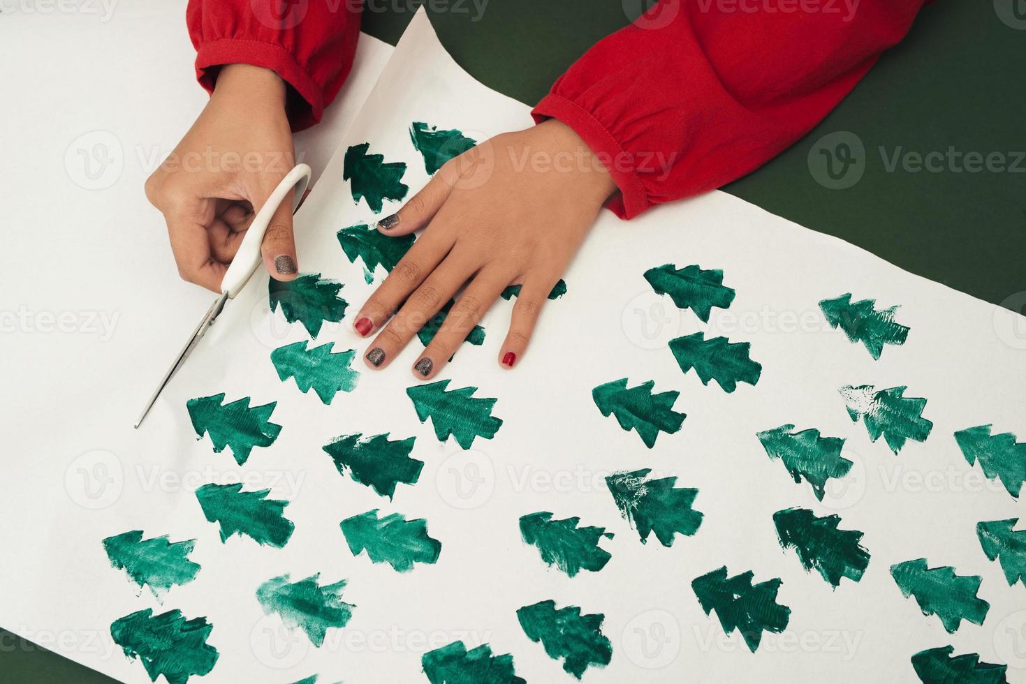 mujer cortando papel kraft y haciendo sobres en taller, estudio. concepto hecho a mano y de navidad foto