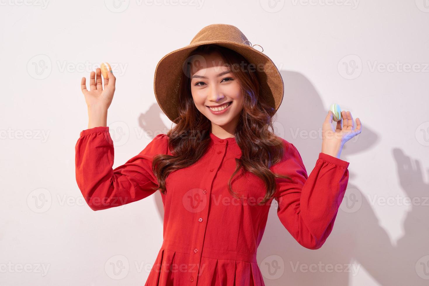 Young woman standing with french sweet cookie macaron over white background photo