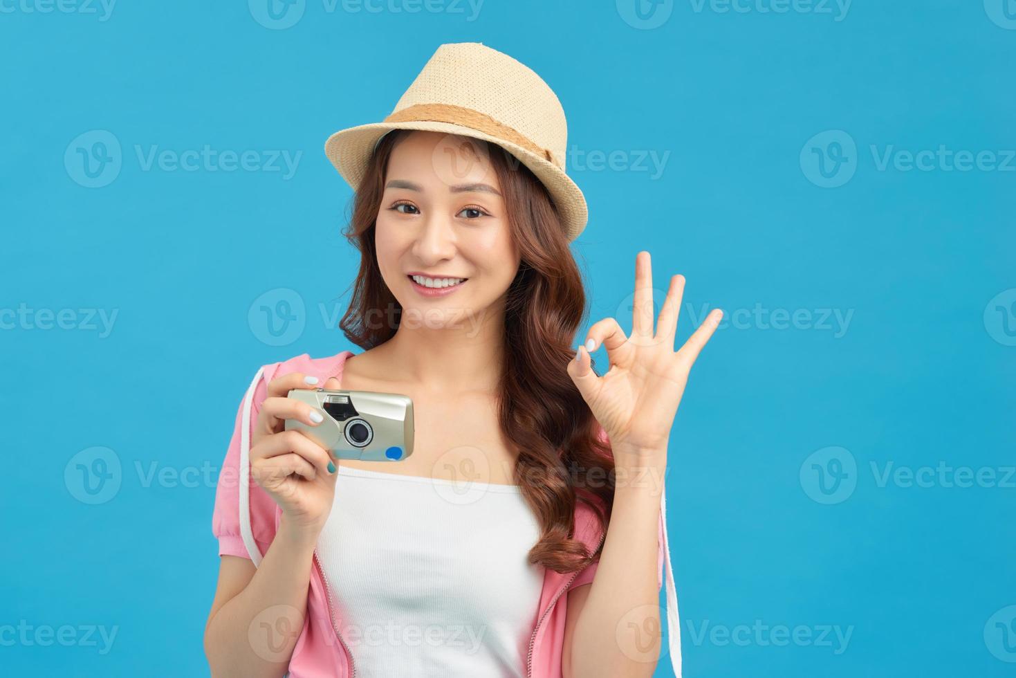 Close-up image of a traveler making a photo of something over a blue background