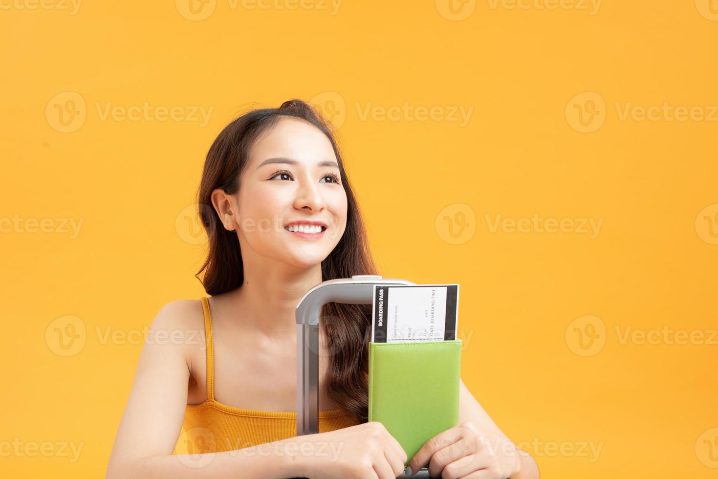 Travel concept. Portrait of pretty young woman holding passport with tickets with luggage photo