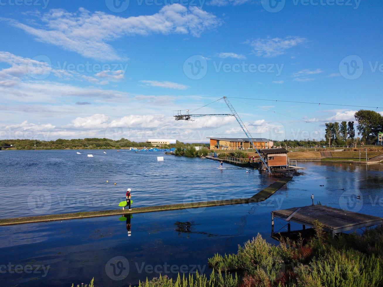 Beautiful Aerial Drone's Camera  Footage of Willen Lake and Park which is located at Milton Keynes, England. People are Enjoying at Lake on a Hot Sunny Day of Summer photo