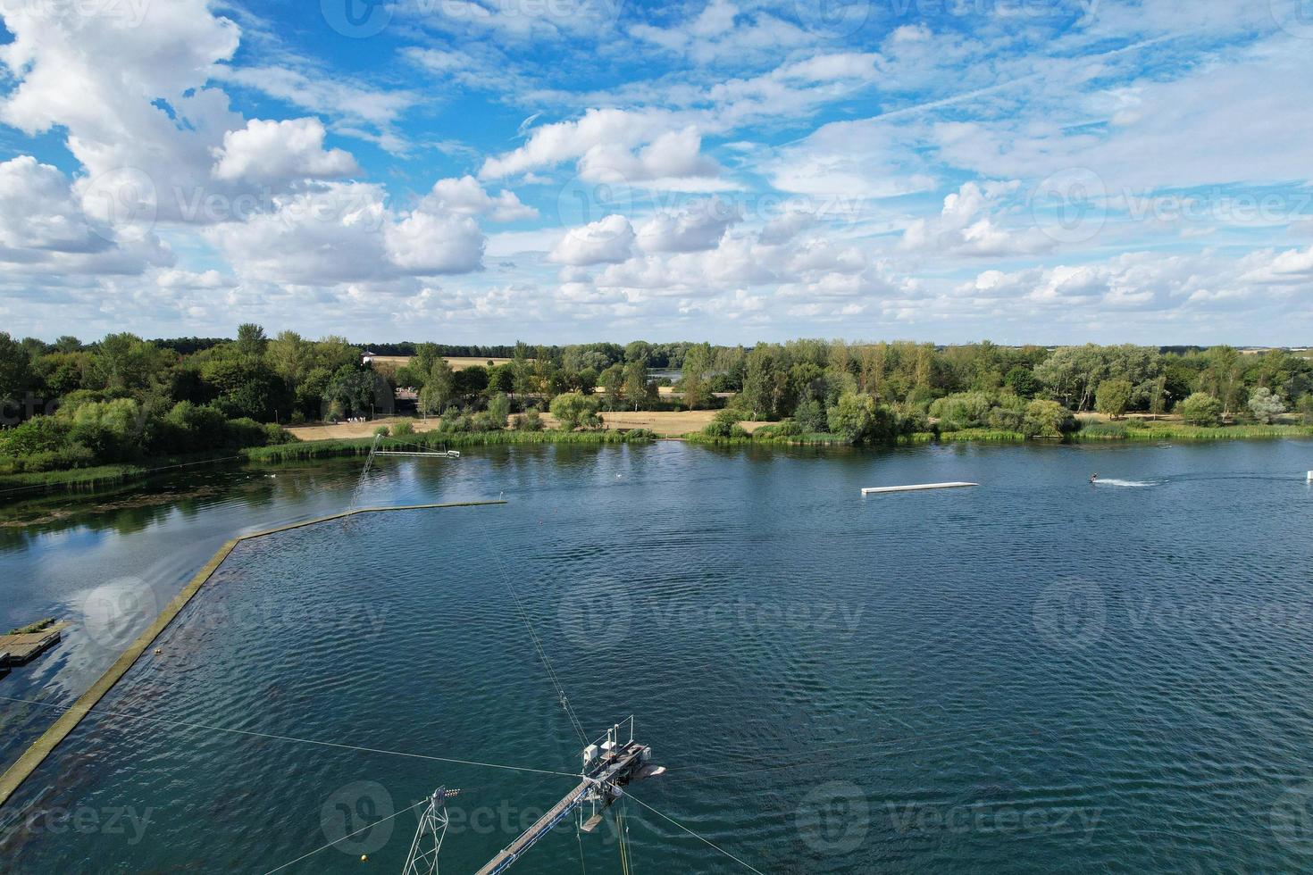 Beautiful Aerial Drone's Camera  Footage of Willen Lake and Park which is located at Milton Keynes, England. People are Enjoying at Lake on a Hot Sunny Day of Summer photo