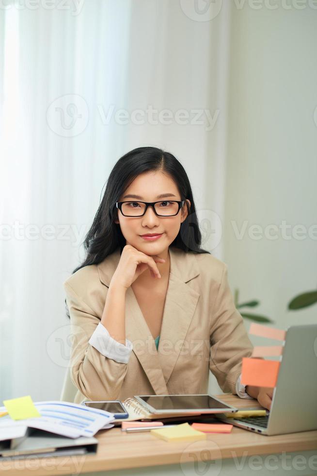 Young female gardener in glasses using laptop, communicates on internet with customer in home photo
