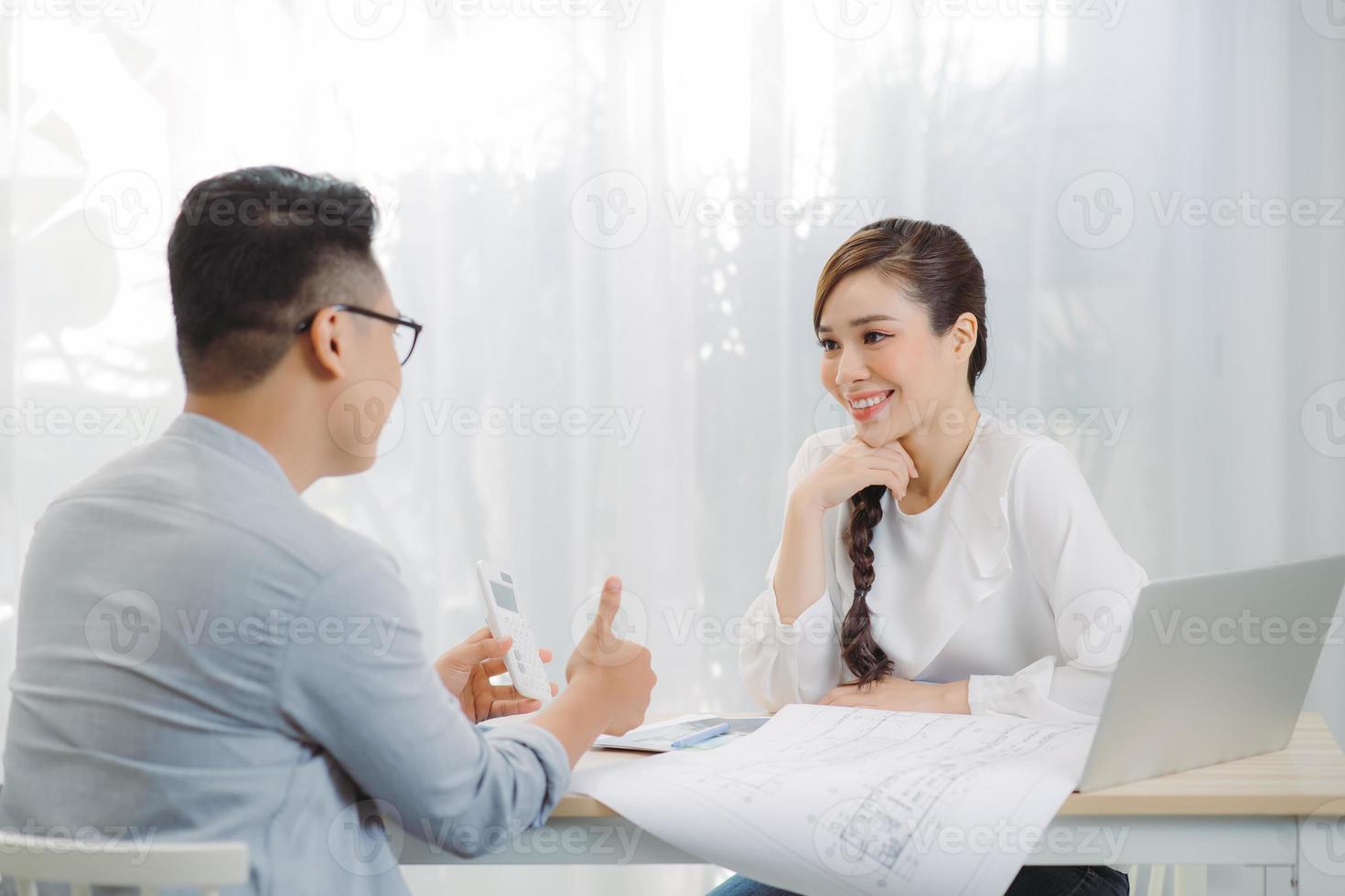 Young Asian man at real estate agent in office with famale seller. photo