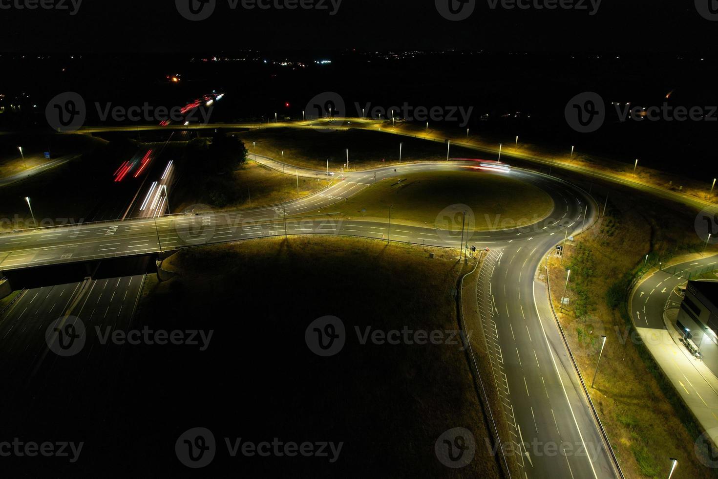 Night Aerial View of British Motorways with illuminated Roads and Traffic. Highways footage taken with drone's camera over Milton Keynes and motorways of England at Dark Night photo
