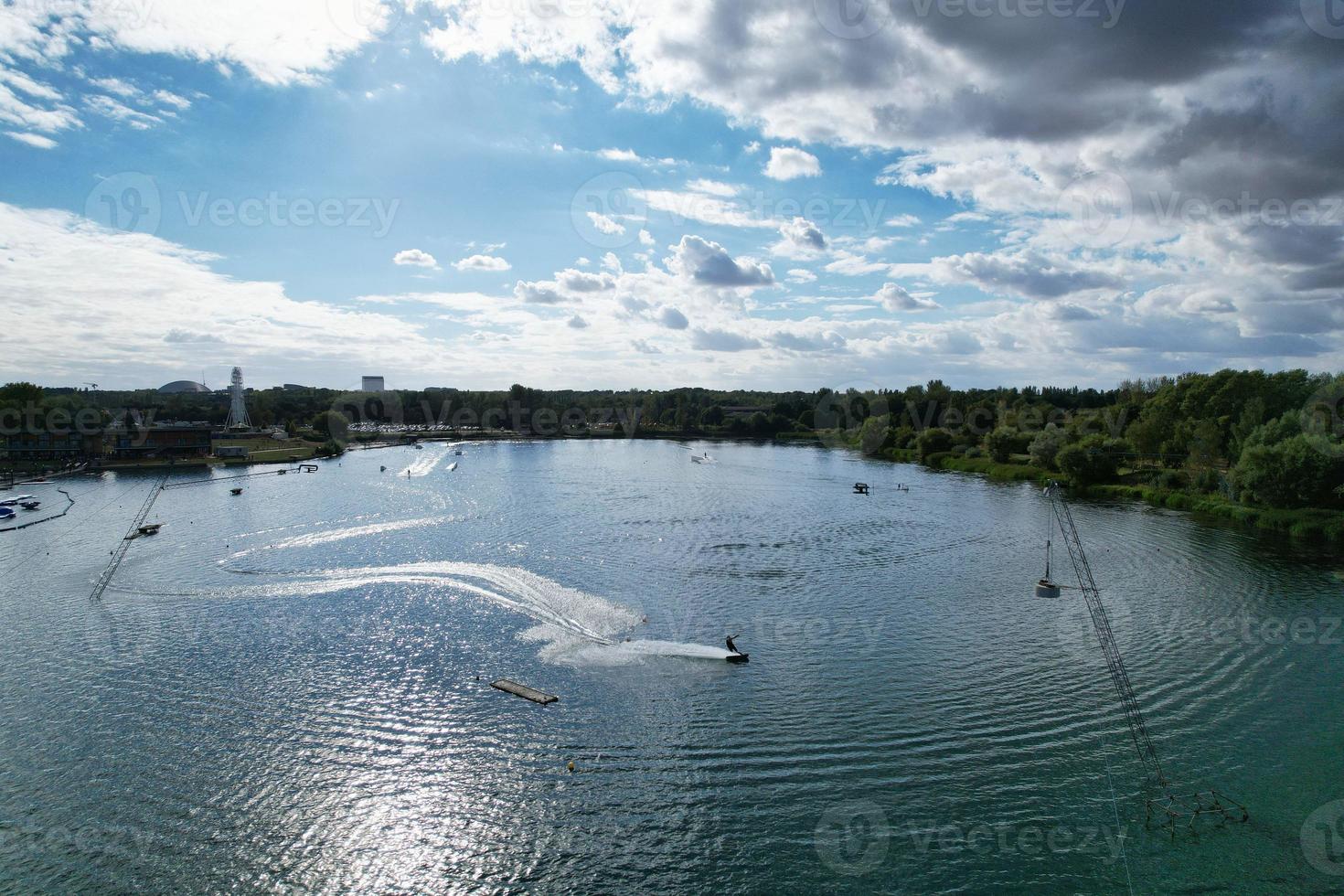 bellas imágenes de la cámara de drones aéreos del lago y parque willen que se encuentra en milton keynes, inglaterra. la gente está disfrutando en el lago en un caluroso día soleado de verano foto