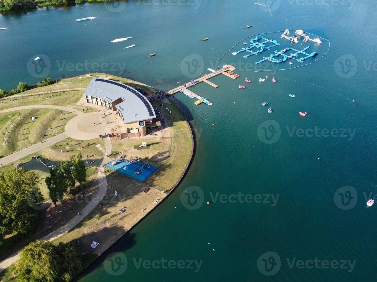 Beautiful Aerial Drone's Camera  Footage of Willen Lake and Park which is located at Milton Keynes, England. People are Enjoying at Lake on a Hot Sunny Day of Summer photo