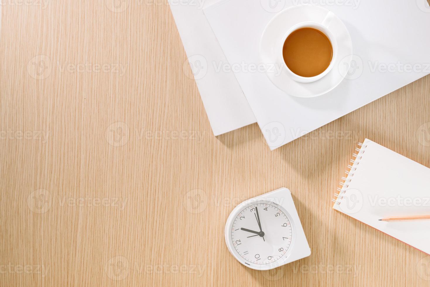 endecha plana de taza de café, reloj, lápiz y un cuaderno. foto