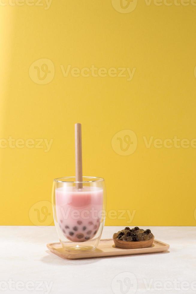Strawberry flavor boba tea isolated on yellow background photo