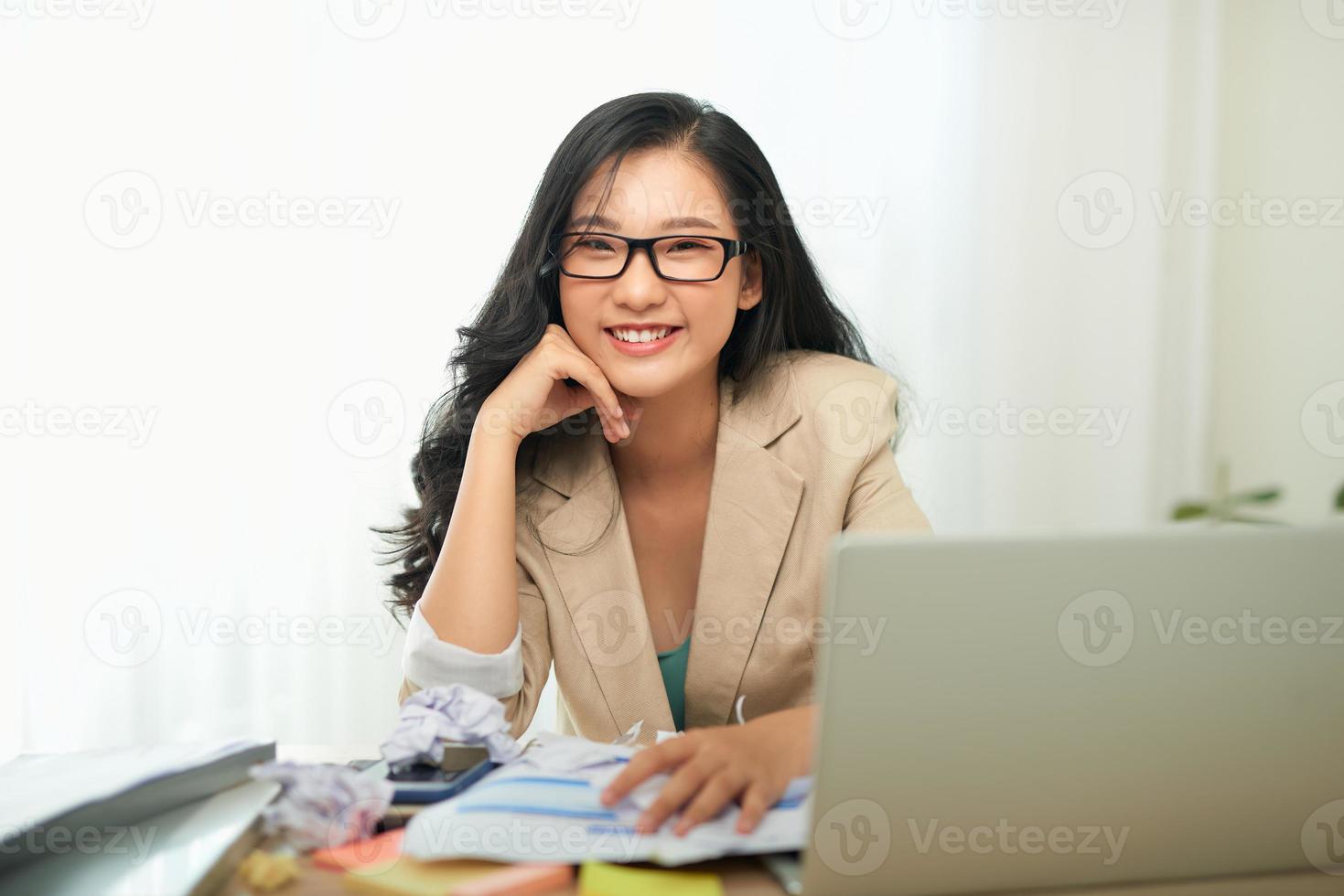 una mujer en una oficina, trabajando en una computadora portátil. foto