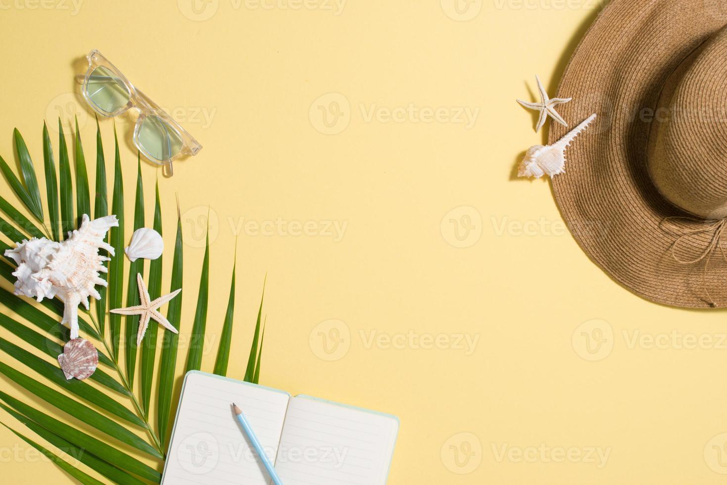 coloridas vacaciones de verano moda plana - sombrero de paja, gafas de sol, conchas marinas sobre fondo amarillo brillante foto