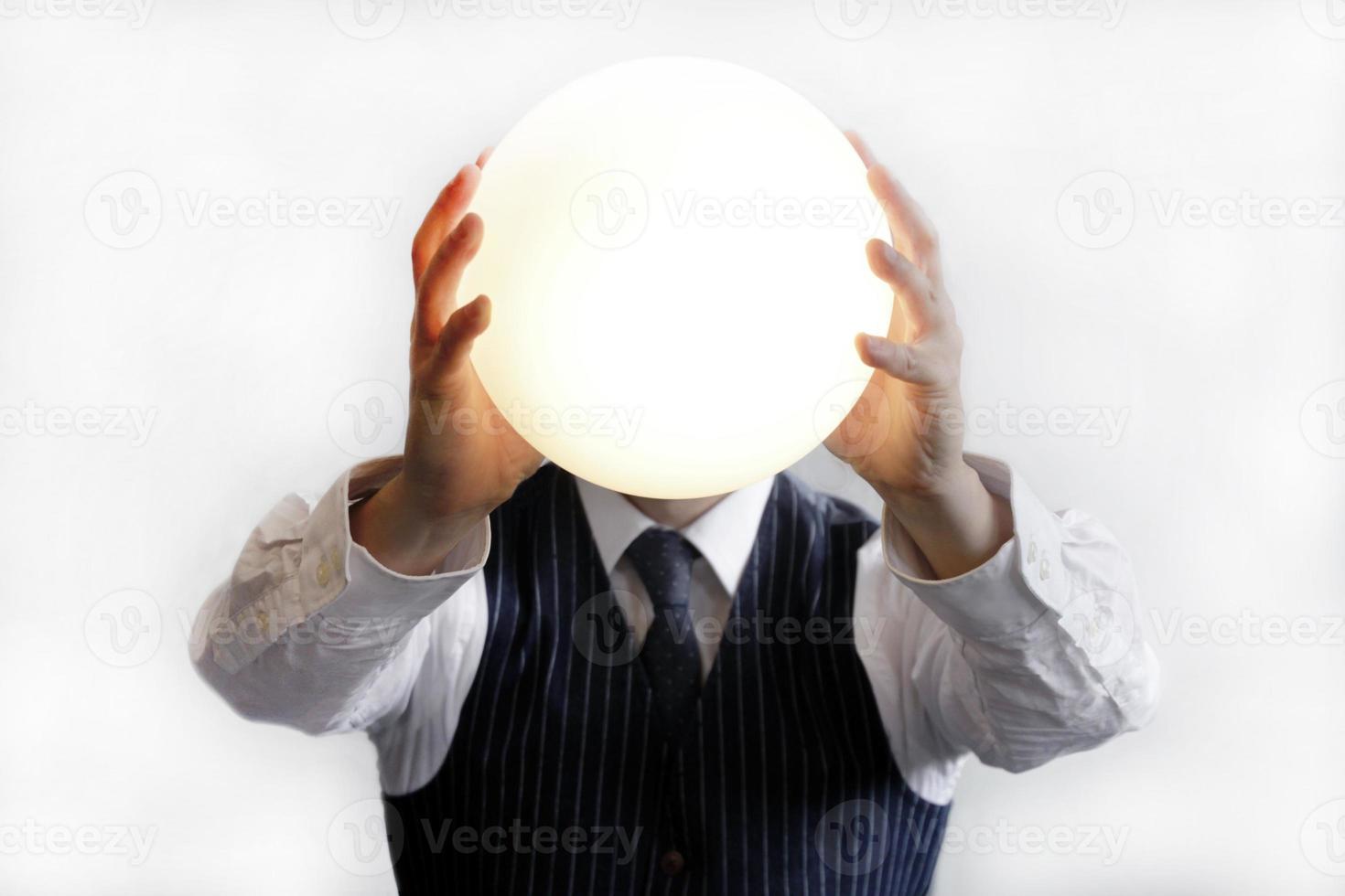 Businessman holding up a glowing ball photo