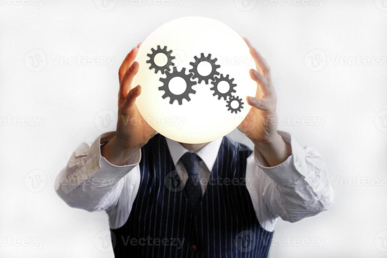 Businessman holding up a glowing ball with a process icon on it photo
