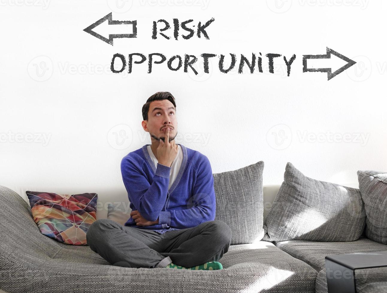 Man contemplating on couch, trying to decide between Risk and Opportunity photo