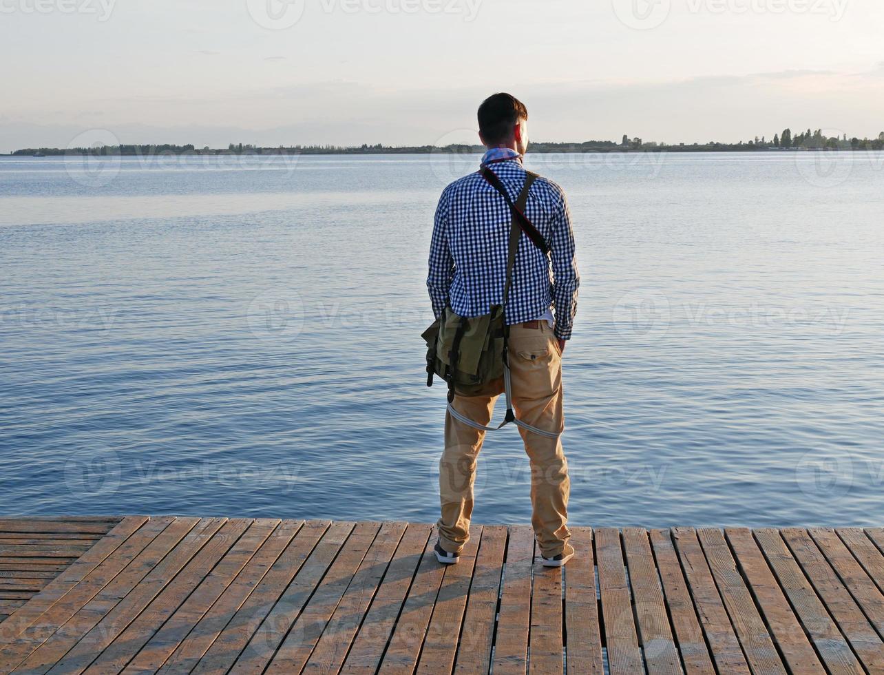 Man looking out at a lake in the afternoon hours photo