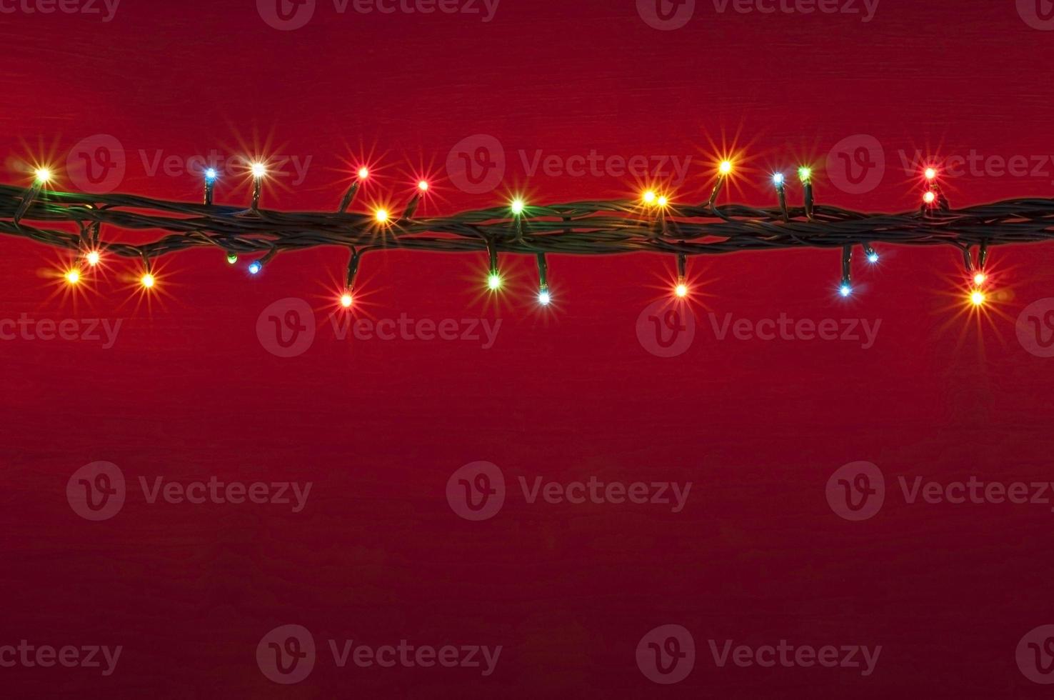 Christmas lights on red background. Multicolored light. Colorful light background. photo