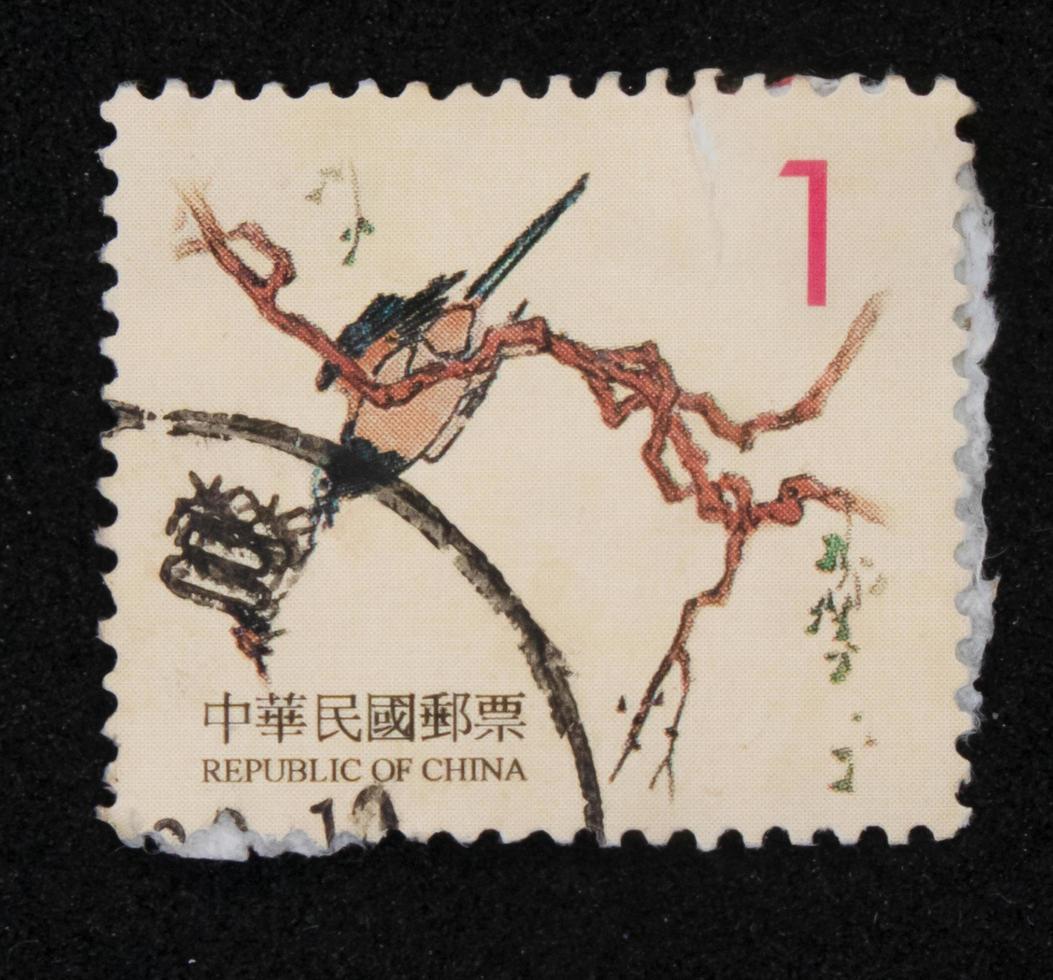 Sidoarjo, Jawa timur, Indonesia, 2022 - Stamp collection philately with the theme of an illustration of a bird perching on a tree photo