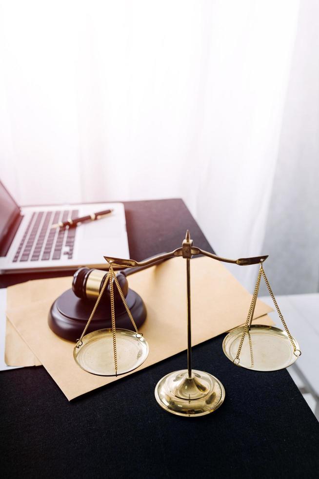 Justice and law concept.Male judge in a courtroom with the gavel, working with, computer and docking keyboard, eyeglasses, on table in morning light photo