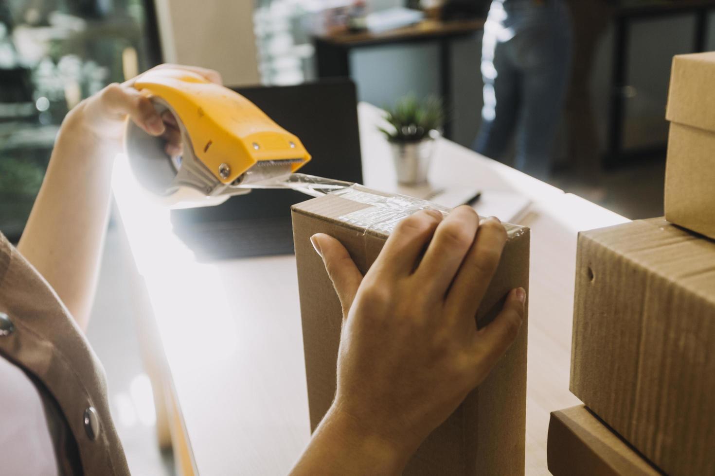 retrato de propietarios de pymes que inician pequeñas empresas, dos mujeres asiáticas revisan pedidos en línea que venden productos que trabajan con cajas de trabajo independiente en la oficina doméstica, pymes en línea pequeña empresa mediana foto