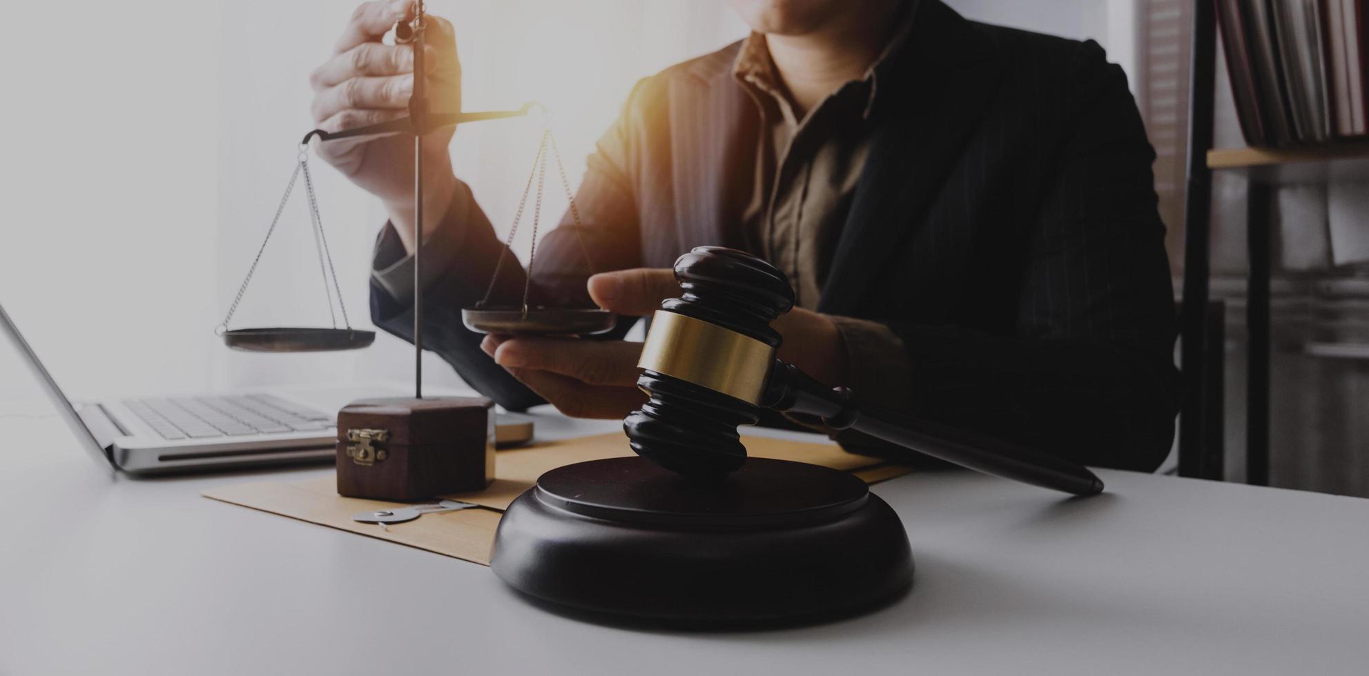 Business and lawyers discussing contract papers with brass scale on desk in office. Law, legal services, advice, justice and law concept picture with film grain effect photo