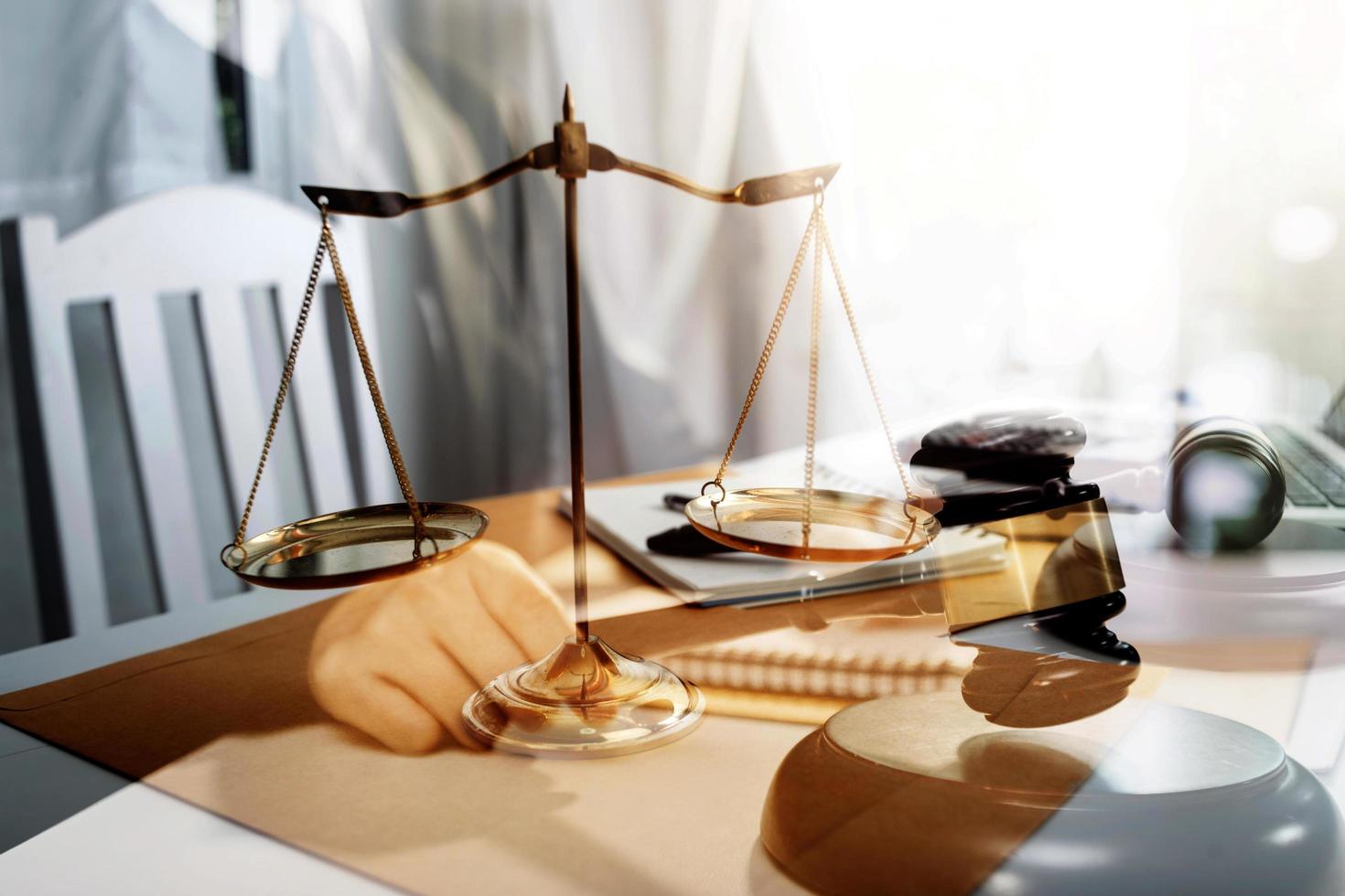 Business and lawyers discussing contract papers with brass scale on desk in office. Law, legal services, advice, justice and law concept picture with film grain effect photo